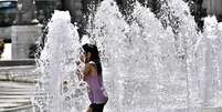 Menina se refresca do calor em fonte em G&ecirc;nova, noroeste da It&aacute;lia  Foto: ANSA / Ansa - Brasil