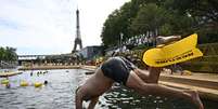 Banhista mergulha no rio Sena em um dos pontos autorizados para o nado, perto da torre Eiffel, neste sábado, 5 de julho de 2025.  Foto: AFP - JULIEN DE ROSA / RFI
