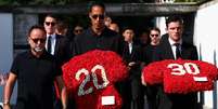 Virgil van Dijk e Andrew Robertson seguram coroas de flores com os números 20 e 30. Foto: Reuters / BBC News Brasil