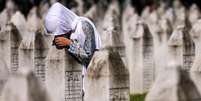 Uma mulher bósnia chora no túmulo de um parente que foi assassinado no genocídio de Srebrenica  Foto: DW / Deutsche Welle
