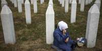 Uma muçulmana bósnia presta homenagem no túmulo de um /parente, vítima do genocídio de Srebrenica. 10/07/25.  Foto: AP - Armin Durgut / RFI