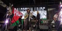 O grupo se apresentava na praça do Patriarca, localizada na região central da cidade  Foto: Sophia Chablau e Uma Enorme Perda de Tempo exibe imagem pró-Palestina durante show ( Reprodução) / Rolling Stone Brasil