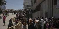 Palestinos fazem fila para receber sacos de farinha distribuídos pelo Programa Mundial de Alimentos (PMA) na Cidade de Gaza, norte da Faixa de Gaza, sábado, 12 de julho de 2025.  Foto: AP - Jehad Alshrafi / RFI