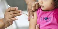 Foto de criança recebendo imunizante  Foto: Marcelo Camargo/Agência Brasil