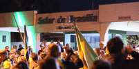 Apoiadores do ex-presidente Jair Messias Bolsonaro (PL) reunidos em uma das entradas do condomínio Solar de Brasília, onde ele mora, em Brasília (DF), na noite desta segunda-feira, 4 de agosto de 2025.  Foto: EDUARDO F. S LIMA/ATO PRESS/ESTADÃO CONTEÚDO
