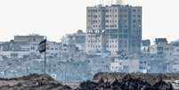 Uma bandeira israelense danificada em Gaza, vista do lado israelense da fronteira entre Israel e o territ&oacute;rio palestino, em 7 de agosto de 2025.  Foto: REUTERS - Amir Cohen / RFI