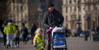 Foto ilustrativa de uma mulher andando com uma criança na Praça da Independência de Kiev.  Foto: © AP - Vadim Ghirda / RFI