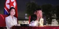 Foto tirada em 24 de junho de 2025 e publicada pela agência de notícias oficial KCNA em 26 de junho de 2025 mostra o líder norte-coreano Kim Jong-un e sua filha Kim Ju-ae assistindo a um espetáculo em comemoração à conclusão da zona turística costeira de Wonsan Kalma, na província de Kangwon, na Coreia do Norte.  Foto: AFP - STR / RFI