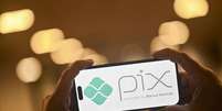 Em imagem de ilustração, um smartphone exibe o logotipo do Pix, o sistema de pagamento instantâneo gratuito do Brasil desenvolvido pelo Banco Central.  Foto: AFP - MAURO PIMENTEL / RFI