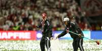 Funcionários do Inter improvisam para limpar papel picado do gramado  Foto: Pedro H. Tesch/Getty Images