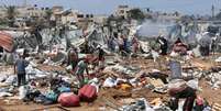 Palestinos observam os danos causados pelo ataque israelense a um acampamento de refugiados na região central da Faixa de Gaza, em 21 de agosto de 2025.  Foto: © Ramadan Abed / Reuters / RFI