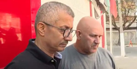 À esquerda de camiseta preta, o piloto de avião aposentado, suspeito de estupro Foto: Reprodução/TV Record