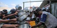 Homens e meninos palestinos aguardam comida em Khan Younès, no sul da Faixa de Gaza, em 21 de agosto.  Foto: AFP - - / RFI
