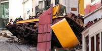 Uma das duas cabines do bondinho despencou pela rua íngreme, descarrilou e colidiu com um prédio  Foto: Reuters / BBC News Brasil