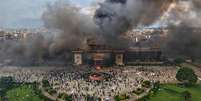 Manifestantes comemoram no prédio do parlamento após ele ter sido incendiado durante um protesto contra a proibição das redes sociais e a corrupção em Katmandu, Nepal, terça-feira, 9 de setembro de 2025.  Foto: AP - Prakash Timalsina / RFI