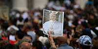 Fieis reunidos na Praça de São Pedro seguram uma imagem do Papa Leão XIV para lhe desejar um feliz aniversário, durante sua oração do Angelus, no Vaticano, em 14 de setembro de 2025.  Foto: AFP - FILIPPO MONTEFORTE / RFI