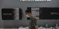 Um visitante passa diante dos componentes de baterias fabricados pela Contemporary Amperex Technology Co., Limited (CATL) expostos em seu estande durante a 3ª Feira Internacional da Cadeia de Suprimentos da China, em Pequim, em 17 de julho de 2025. (Imagem ilustrativa)  Foto: AP - Andy Wong / RFI