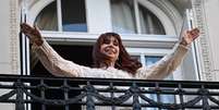 A ex-presidente argentina Cristina Kirchner acena para apoiadores da sacada de sua residência em Buenos Aires, em 11 de junho de 2025.  Foto: AFP - LUIS ROBAYO / RFI