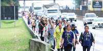 Romeiros caminham pela Rodovia Presidente Dutra (BR-116), na altura da cidade de Taubaté (SP), rumo ao Santuário de Nossa Senhora Aparecida, nesta sexta-feira, 10.  Foto: VITOR VIDAL/AGÊNCIA F8/ESTADÃO CONTEÚDO