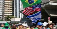 Na Avenida Paulista, manifestantes carregam bandeiras do Brasil, Estados Unidos e Israel, em ato em agosto convocado por aliados de Bolsonaro  Foto: Cadu Pinotti/Agência Brasil / BBC News Brasil