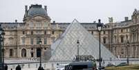 Agentes e ve&iacute;culos da pol&iacute;cia posicionados perto da pir&acirc;mide do Museu do Louvre ap&oacute;s assalto, em Paris, Fran&ccedil;a, em 19 de outubro de 2025.  Foto: REUTERS - Gonzalo Fuentes / RFI
