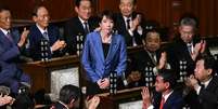 A nova primeira-ministra do Jap&atilde;o, Sanae Takaichi, aplaudida ap&oacute;s ser confirmada no cargo, em T&oacute;quio, 21 de outubro de 2025.  Foto: AFP - PHILIP FONG / RFI