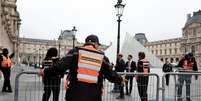 Agentes de segurança colocam barreiras ao redor da pirâmide do Museu do Louvre, em Paris, em 20 de outubro de 2025, um dia após um roubo espetacular.  Foto: REUTERS - Benoit Tessier / RFI