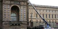 Policiais franceses ao lado da escada elevatória usada por ladrões para entrar no Museu do Louvre, em Paris, em 19 de outubro  Foto: Getty Images / BBC News Brasil