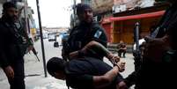 Imagem de um homem detido por agentes da polícia durante a operação policial na favela da Penha, no Rio de Janeiro, nesta terça-feira, 28  Foto: REUTERS/Aline Massuca