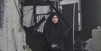 Mulher em meio a destroços de prédio bombardeado por Israel em campo de refugiados  Foto: ANSA / Ansa - Brasil