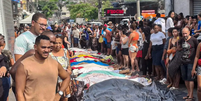 Dezenas de corpos são trazidos por moradores para a Praça São Lucas, na Penha, zona norte do Rio de Janeiro.  Foto: Eusébio Gomes/TV Brasil