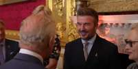  Foto: Reprodução / The Royal Family Channel - Legenda: David Beckham recebe título de cavaleiro das mãos do rei Charles III / Jogada10