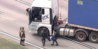Por volta das 9h25, motorista foi retirado do caminhão e socorrido Foto: Reprodução/TV Globo