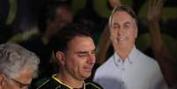 Flávio Bolsonaro ao lado de cartaz representando seu pai, o ex-presidente Jair Bolsonaro, em Brasília, no Distrito Federal, após decretação de prisão preventiva.  Foto: Wilton Junior/Estadão / Estadão