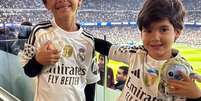 Foto: Reprodução - Legenda: Filhos de Everton Ribeiro, Guto e Totói, visitam o vestiário e tiram fotos com estrelas do Real Madrid / Jogada10