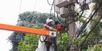 Na foto, funcionário da Enel fazendo conserto em poste de energia elétrica, após relatos de falta de luz.  Foto: Tiago Queiroz/Estadão / Estadão