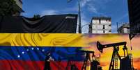 Um homem usando uma m&aacute;scara e passando em frente a um mural com uma m&aacute;quina de extra&ccedil;&atilde;o de &oacute;leo e a bandeira da Venezuela  Foto: AFP via Getty Images / BBC News Brasil