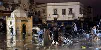 Moradores atravessam uma pra&ccedil;a de Safi, devastada por enchentes neste domingo, 14 de dezembro de 2025.  Foto: &copy; AFP / RFI