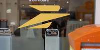 O símbolo do serviço postal francês, La Poste, na vitrine de uma de suas agências.  Foto: © AFP / RFI