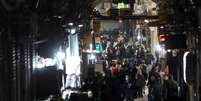 Pessoas caminham diante de lojas fechadas, após os protestos no Grande Bazar de Teerã, no Irã, em 30 de dezembro de 2025.  Foto: © Majid AsgaripouMajid Asgari pour WANA via REUTERS / RFI