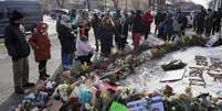 Pessoas reunidas em frente a um memorial improvisado no local onde Alex Pretti foi morto por agentes federais que tentavam prendê-lo, em Minneapolis, em 25 de janeiro de 2026.  Foto: © Reuters/Tim Evans / RFI