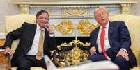 Petro e Trump estão sentados no Salão Oval, lado a lado. Petro sorri e Trump olha para o lado. Foto: Anadolu via Getty Images / BBC News Brasil
