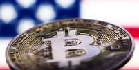 Bandeira dos EUA exibida na tela de um laptop e representação da criptomoeda Bitcoin em 6 de novembro de 2024.  Foto: Getty Images / BBC News Brasil