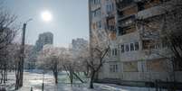 Esta fotografia mostra a neve e o gelo cobrindo o solo em frente a um pr&eacute;dio residencial danificado em Kharkiv, em 4 de fevereiro de 2026.  Foto: AFP - IVAN SAMOILOV / RFI