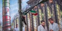 Um cartaz em Teerã retrata equipamentos de enriquecimento de urânio e cientistas iranianos mortos em ataques israelenses em junho de 2025.  Foto: Getty Images / BBC News Brasil