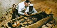O arque&oacute;logo Howard Carter e um auxiliar examinam o caix&atilde;o do fara&oacute; Tutanc&acirc;mon Foto: Instituto Griffith / BBC News Brasil
