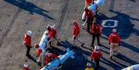 Marinheiros americanos movimentam muni&ccedil;&otilde;es no conv&eacute;s de voo do porta‑avi&otilde;es USS Abraham Lincoln (CVN‑72), da classe Nimitz, durante a Opera&ccedil;&atilde;o F&uacute;ria &Eacute;pica, em 28 de fevereiro de 2026.  Foto: &copy; AFP PHOTO / US NAVY and US CENTRAL COMMAND / HANDOUT / RFI
