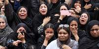Foto divulgada pela ag&ecirc;ncia estatal de not&iacute;cias iraniana Isna mostra mulheres chorando durante o funeral de crian&ccedil;as mortas em um bombardeio que atingiu a escola prim&aacute;ria Shajarah Tayyebeh, em Minab, no Ir&atilde;, em 28 de fevereiro de 2026.  Foto: AFP - AMIRHOSSEIN KHORGOOEI / RFI