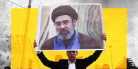 Imagem tratada mostra um homem de terno escuro e camisa branca segurando um cartaz do novo l&iacute;der supremo do Ir&atilde;, Mojtaba Khamenei. Um ret&acirc;ngulo amarelo foi interposto entre o homem e o cartaz, com outras figuras ao fundo  Foto: Getty Images, BBC / BBC News Brasil