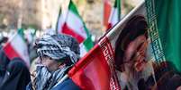Um homem segura uma placa com a imagem do aiatolá Ali Khamenei, o antigo líder supremo assassinado durante a guerra entre o Irã, Israel e os Estados Unidos.  Foto: Getty Images / BBC News Brasil
